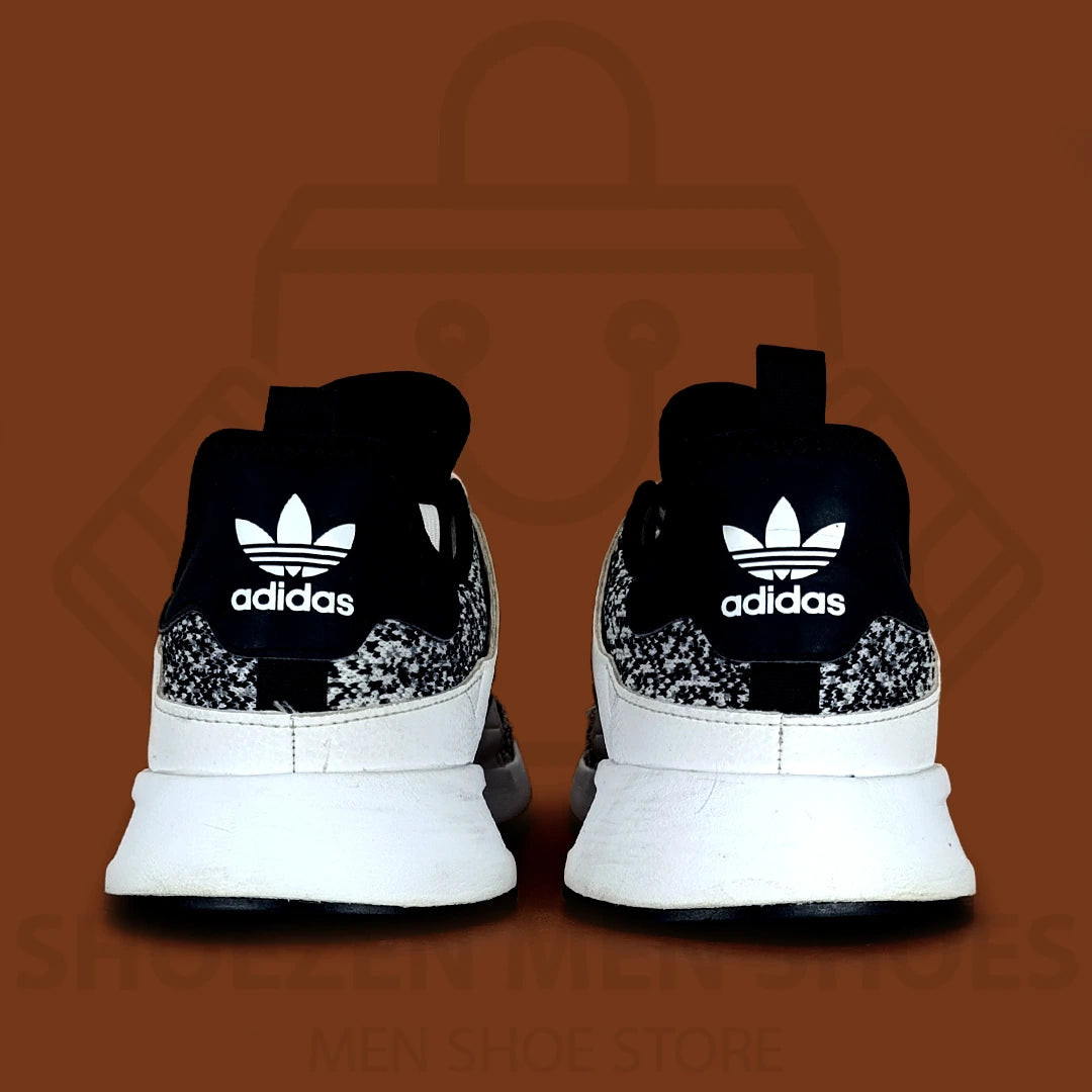 Adi XPLR 'Oreo' Joggers - Shoezen Men Shoes - Black and white sneaker with patterned sole on a brown background