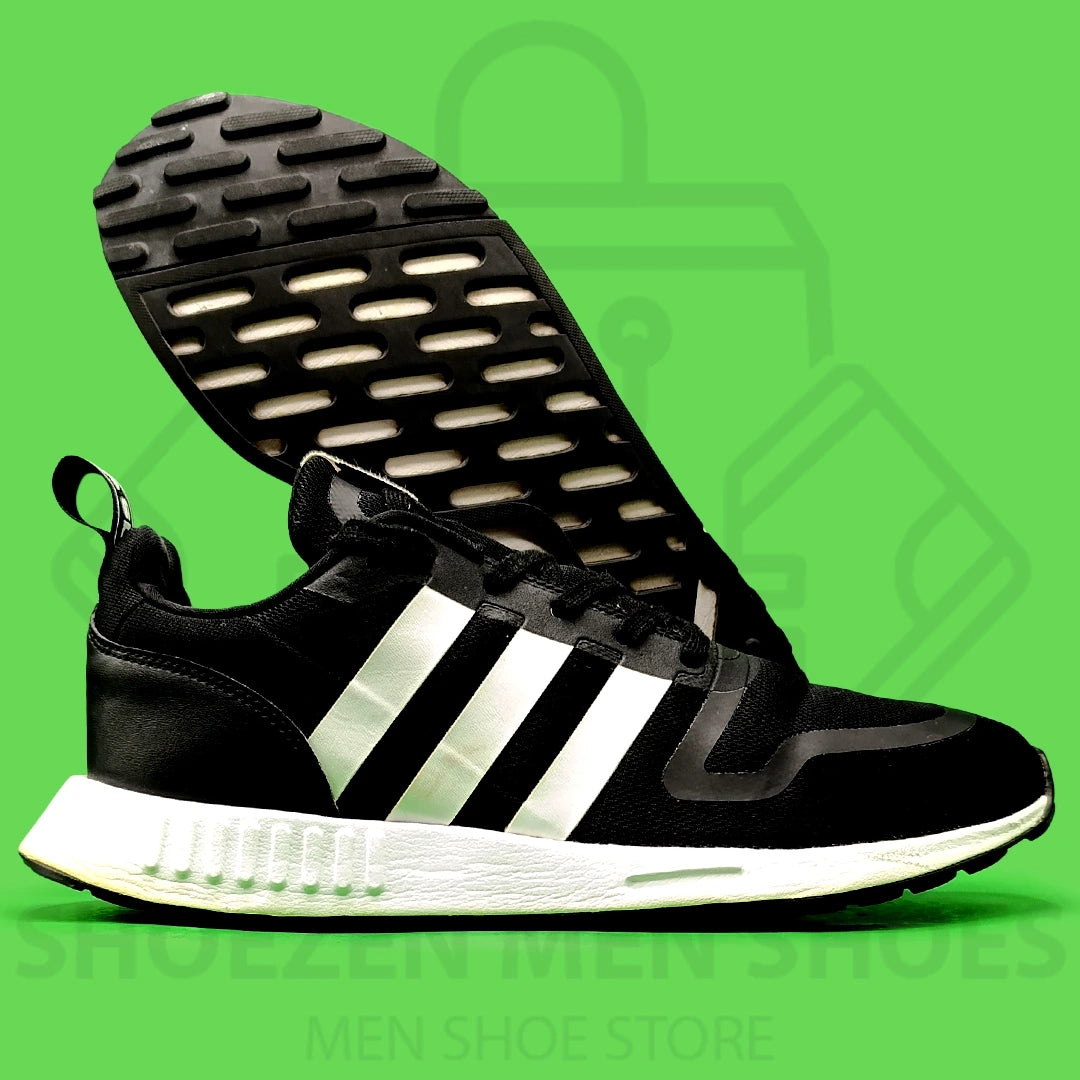 Nk Multix Shoes - Shoezen Men Shoes - Black Adidas sneaker with white stripes on a green background