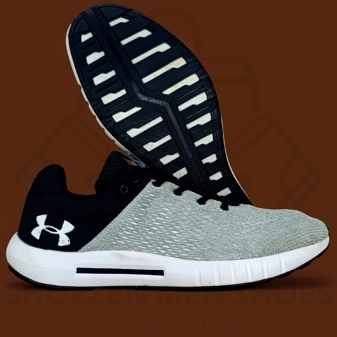 UA Men's Micro G Pursuit Running Shoes - Shoezen Men Shoes - Gray and black sneaker with Under Armour logo on a brown background
