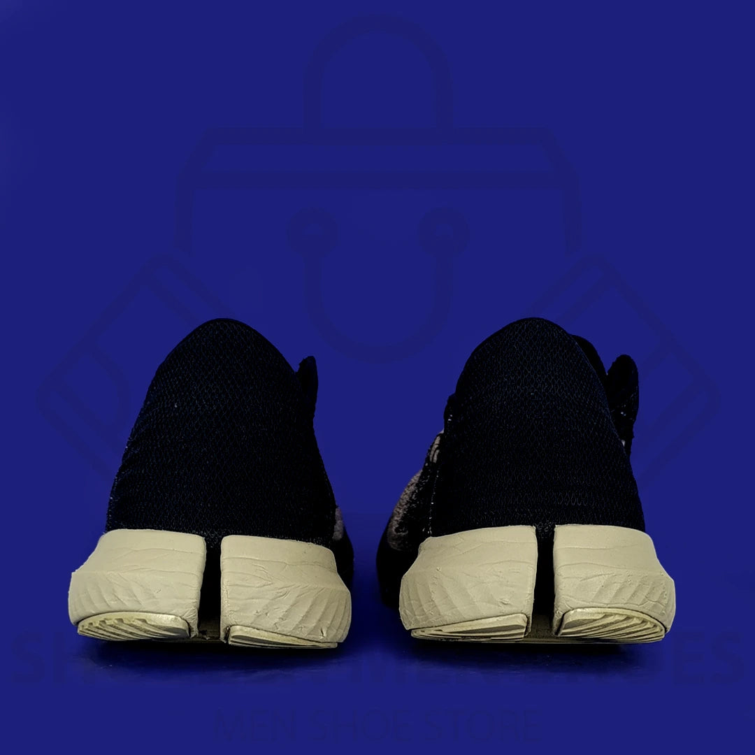 UA Threadborne Blur Running Shoes - Shoezen Men Shoes - Black athletic shoe with beige sole on a blue background